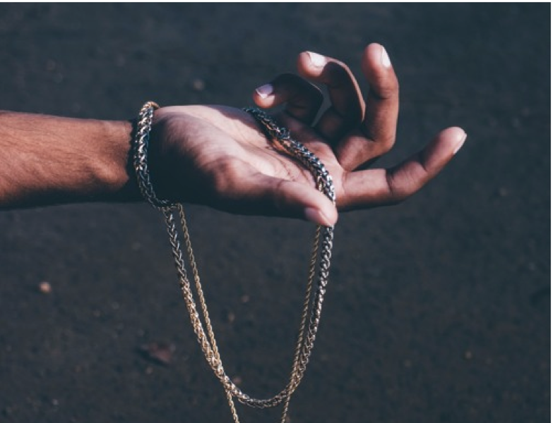 Hand Holding Gold Chains